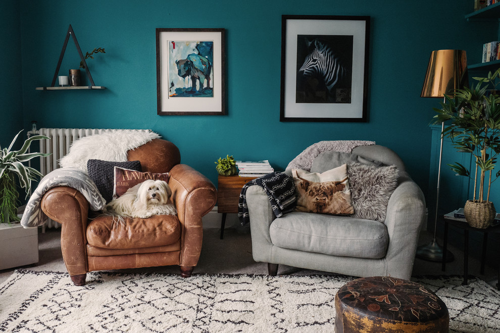 Idee per un soggiorno eclettico con pareti blu e con abbinamento di divani diversi