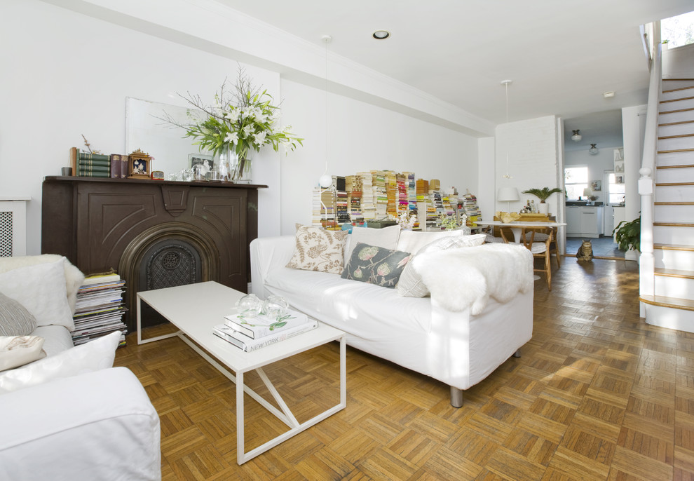 Источник вдохновения для домашнего уюта: гостиная комната в стиле фьюжн с белыми стенами, паркетным полом среднего тона и стандартным камином