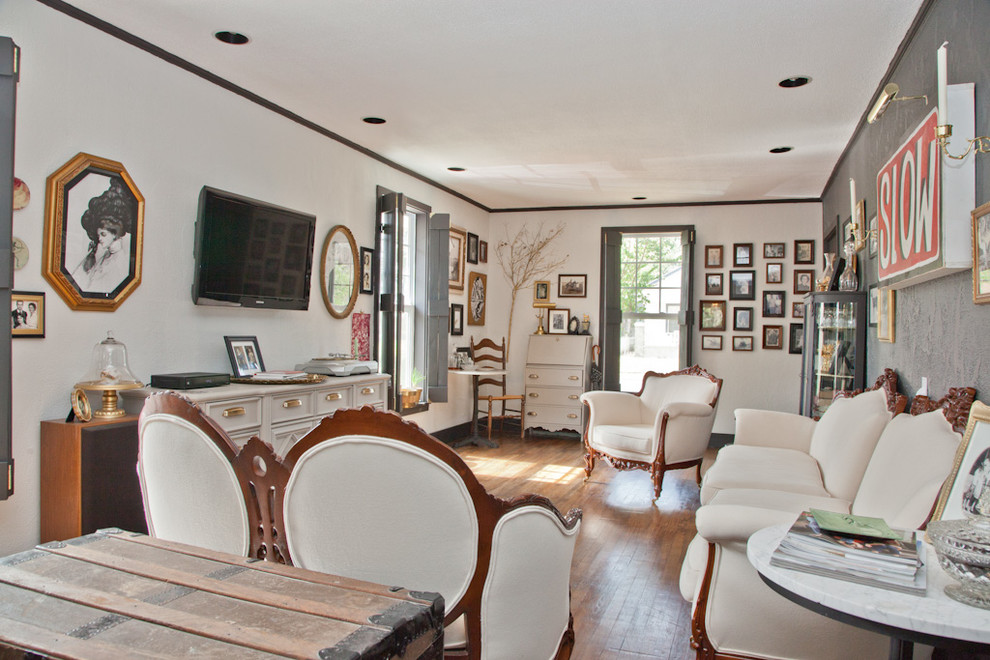 Immagine di un soggiorno vittoriano con pareti bianche, pavimento in legno massello medio e TV a parete