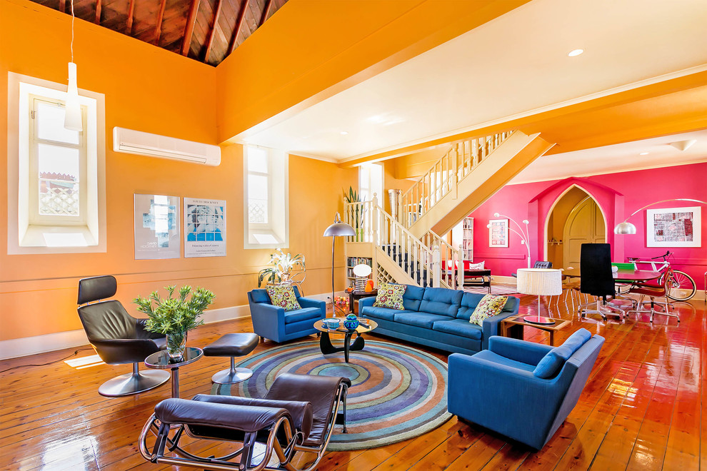 Idées déco pour un grand salon éclectique ouvert avec un mur multicolore et parquet clair.