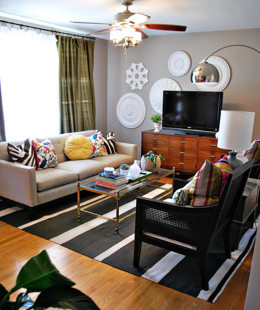 Living room - mid-sized eclectic medium tone wood floor living room idea in St Louis with gray walls and a tv stand