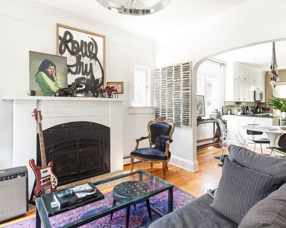 Eklektisches Wohnzimmer mit weißer Wandfarbe, braunem Holzboden, Kamin und braunem Boden in New York