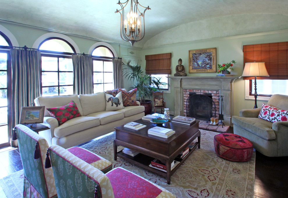 Пример оригинального дизайна: гостиная комната в стиле фьюжн с стандартным камином и фасадом камина из кирпича