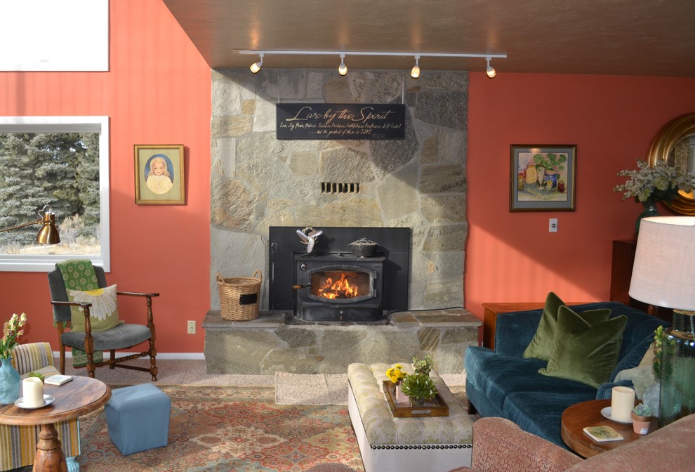 Cette photo montre un grand salon éclectique ouvert avec une salle de réception, un mur rouge, moquette, une cheminée standard, un manteau de cheminée en pierre, aucun téléviseur et un sol beige.