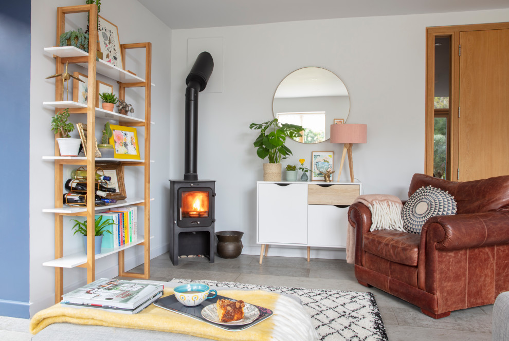 This is an example of a medium sized eclectic living room in Sussex with a wood burning stove and a freestanding tv.