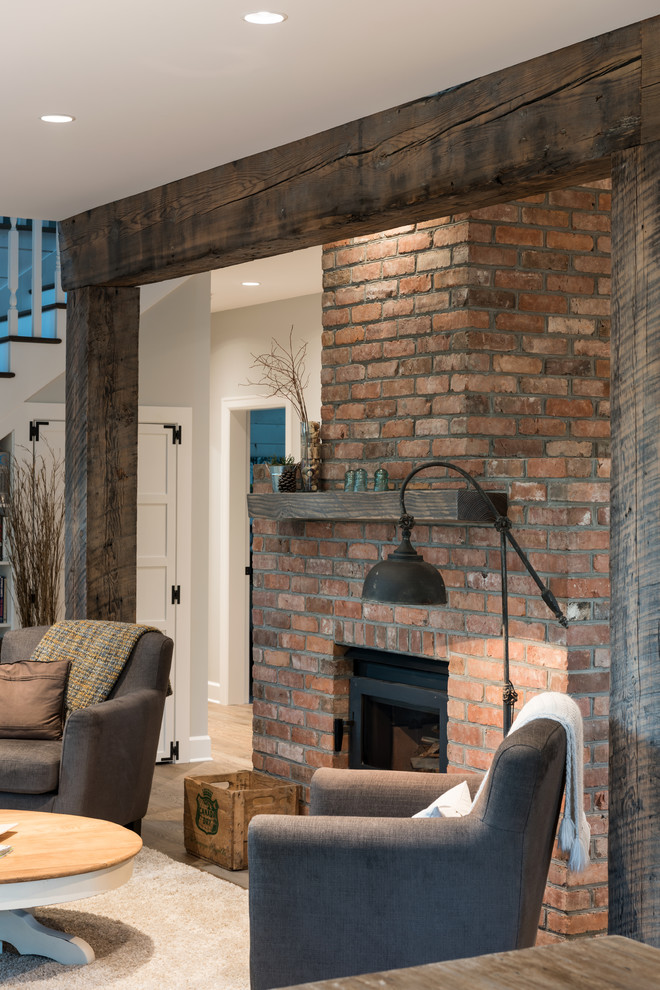Inspiration for a medium sized rural open plan living room in Vancouver with medium hardwood flooring, a wood burning stove and a brick fireplace surround.
