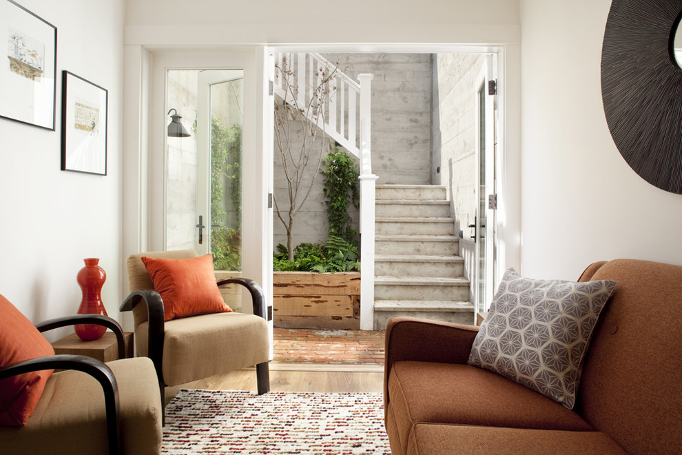 На фото: маленькая гостиная комната в современном стиле с белыми стенами и ковром на полу для на участке и в саду