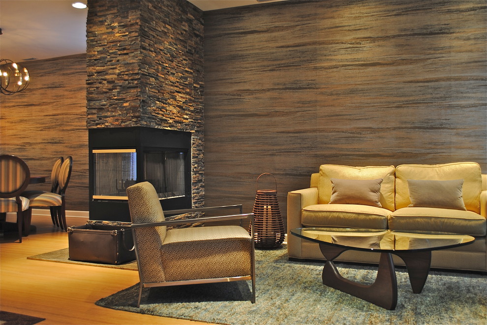 アトランタにある中くらいなトラディショナルスタイルのおしゃれなリビング (マルチカラーの壁、淡色無垢フローリング、両方向型暖炉、石材の暖炉まわり) の写真