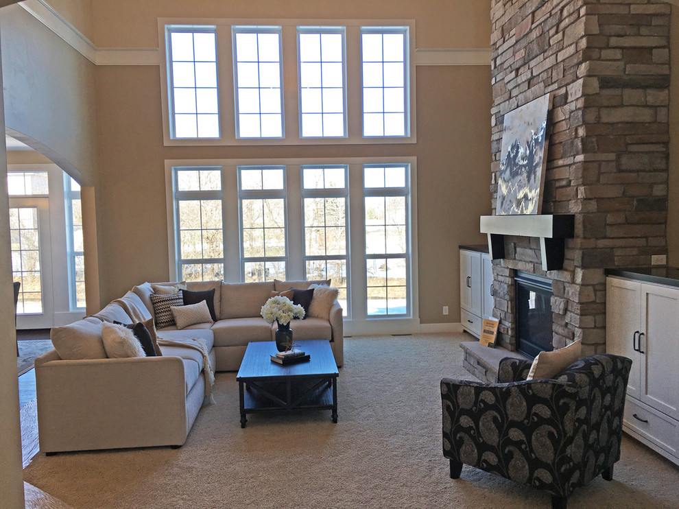Foto de salón para visitas abierto de estilo americano grande sin televisor con paredes beige, moqueta, todas las chimeneas y marco de chimenea de piedra