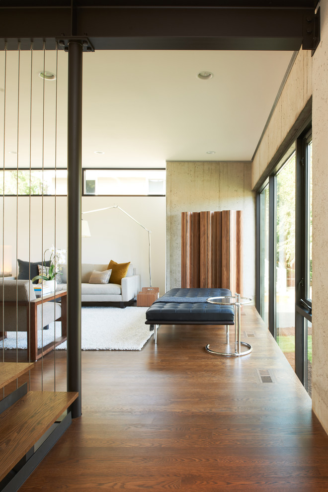 Aménagement d'un salon moderne avec un sol en bois brun, un sol marron et un escalier.