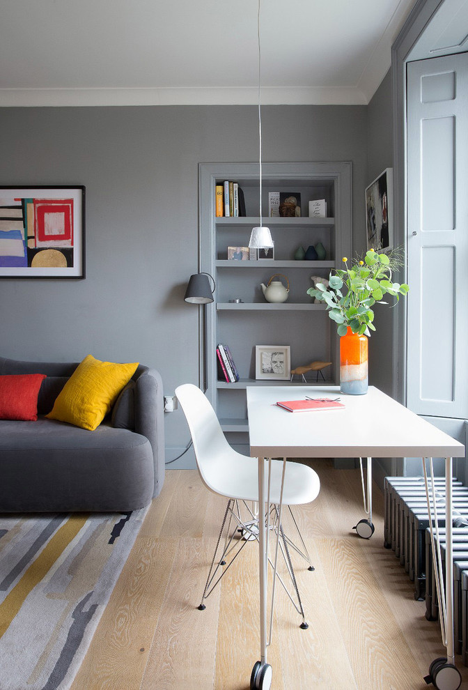 Inspiration pour un salon design ouvert avec un mur gris, parquet clair, aucune cheminée, un téléviseur fixé au mur et un sol beige.
