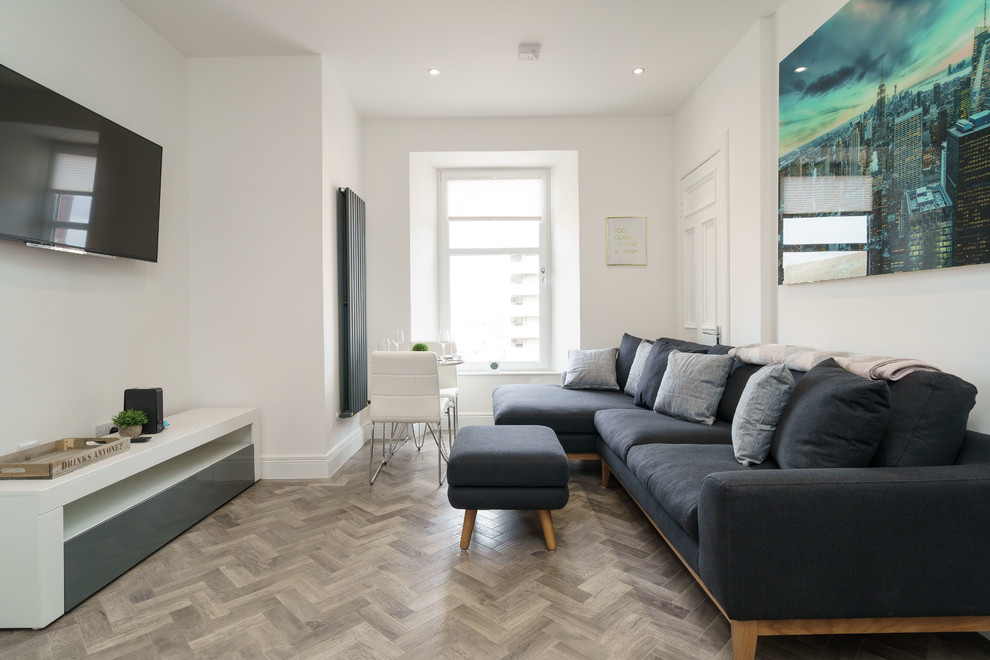 Small classic enclosed living room in Edinburgh with white walls, medium hardwood flooring, a wall mounted tv and brown floors.