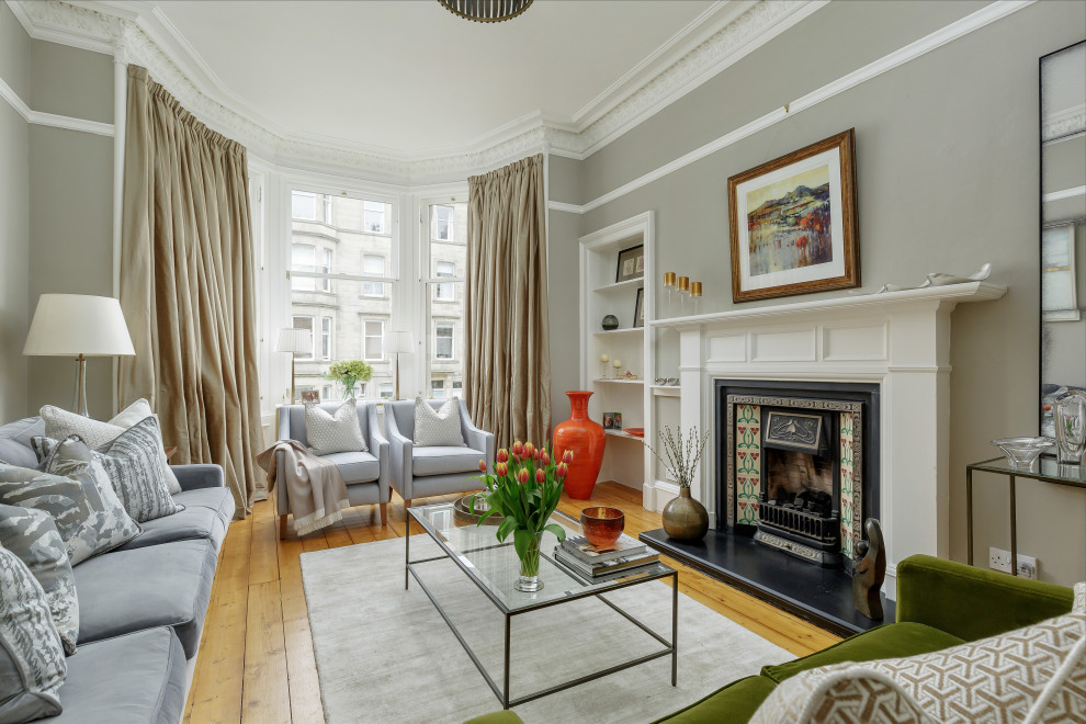 Traditional living room in Edinburgh with light hardwood flooring, a standard fireplace and no tv.
