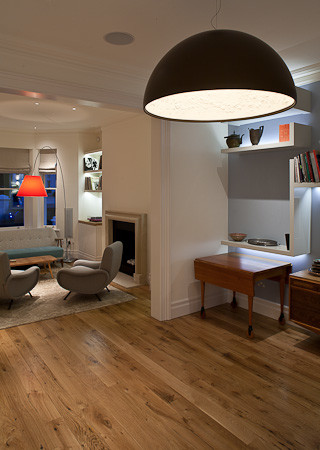 Esempio di un soggiorno moderno di medie dimensioni e aperto con libreria, pareti blu e parquet chiaro