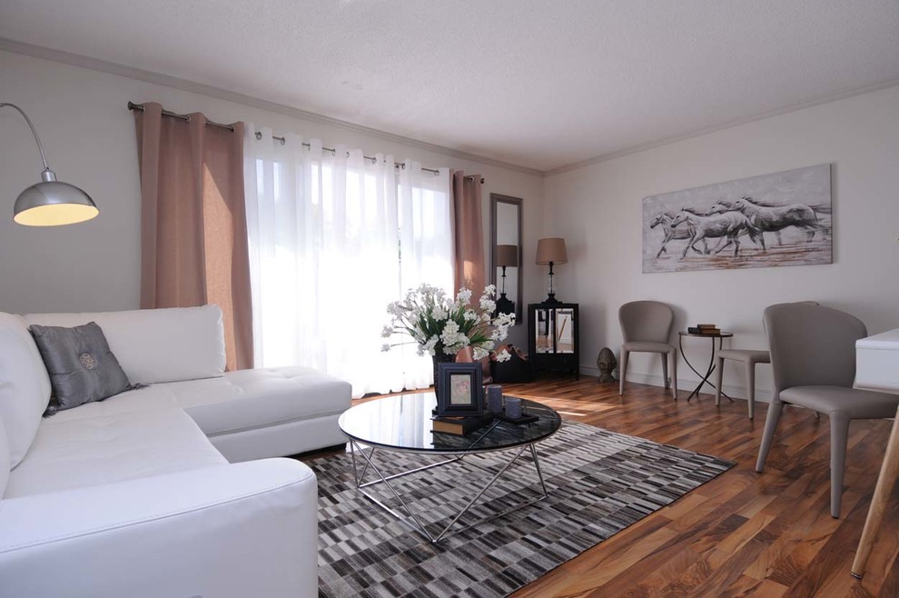 Mittelgroßes, Repräsentatives, Fernseherloses, Abgetrenntes Modernes Wohnzimmer ohne Kamin mit weißer Wandfarbe, braunem Holzboden und braunem Boden in Calgary