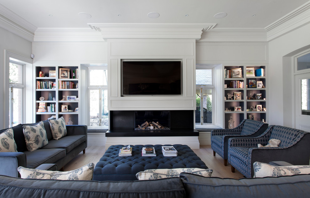 Источник вдохновения для домашнего уюта: гостиная комната в стиле неоклассика (современная классика) с белыми стенами, паркетным полом среднего тона, стандартным камином, телевизором на стене, коричневым полом и синим диваном