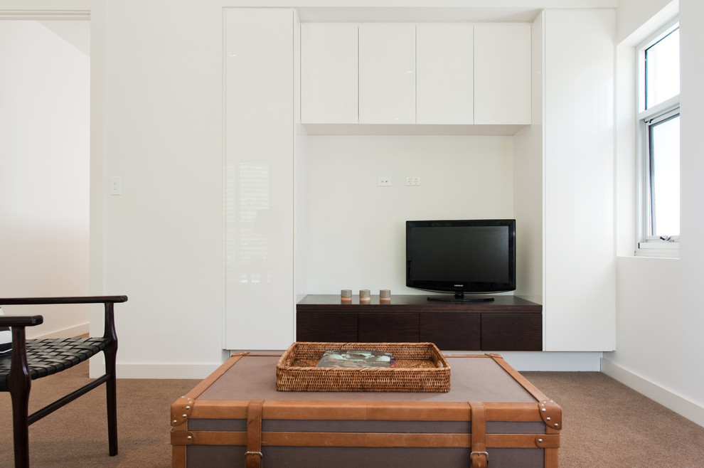 Small contemporary enclosed living room in Adelaide with white walls, carpet and a freestanding tv.