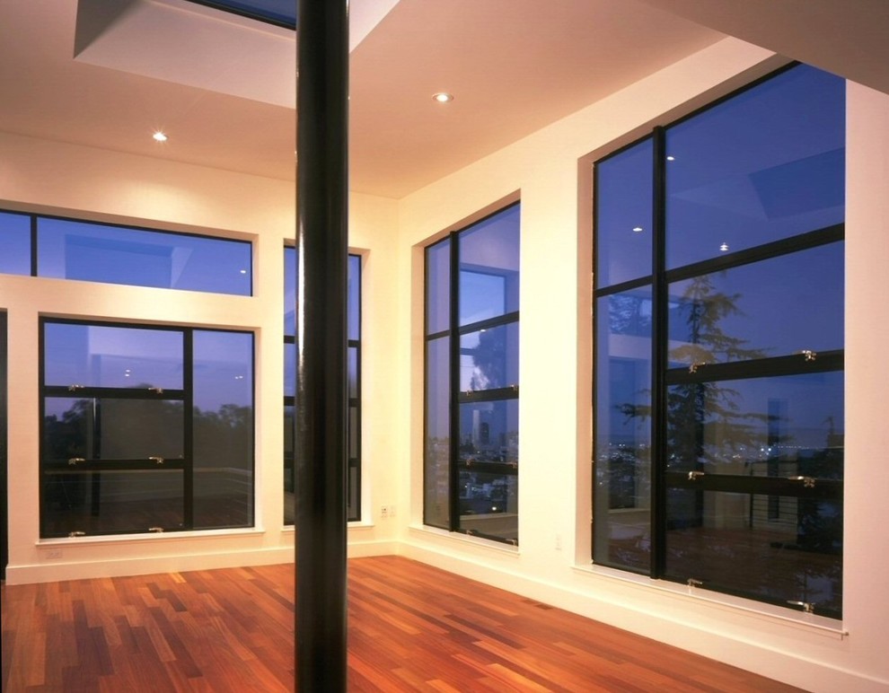 Foto de salón abierto moderno con paredes blancas y suelo de madera en tonos medios
