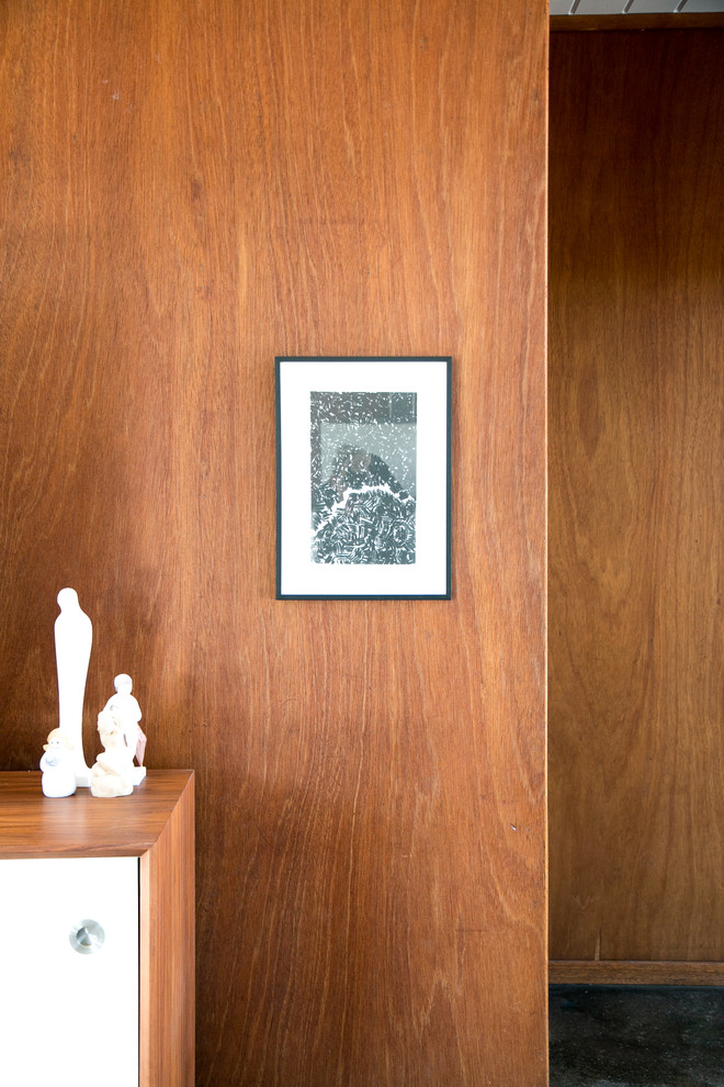 Mittelgroßes, Offenes Mid-Century Wohnzimmer mit brauner Wandfarbe, Betonboden, Kamin, Kaminumrandung aus Backstein und freistehendem TV in San Francisco