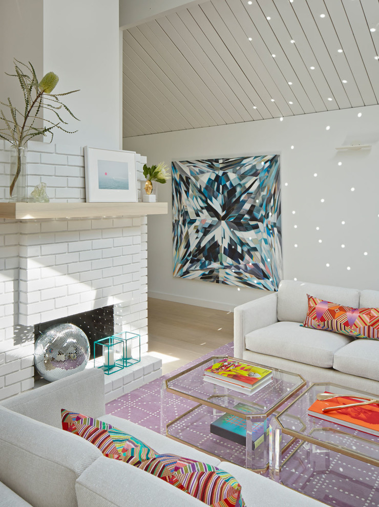 Стильный дизайн: парадная гостиная комната в стиле ретро с белыми стенами, светлым паркетным полом, стандартным камином и фасадом камина из кирпича - последний тренд