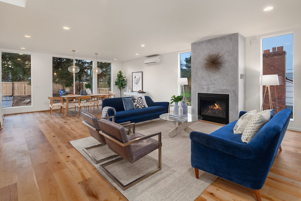 Design ideas for a contemporary formal open plan living room in Seattle with white walls, light hardwood flooring and a standard fireplace.