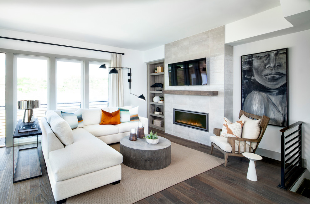 Inredning av ett modernt vardagsrum, med vita väggar, mörkt trägolv, en standard öppen spis, en väggmonterad TV och brunt golv