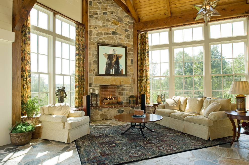 Diseño de salón abierto tradicional grande con chimenea de esquina, marco de chimenea de piedra y alfombra