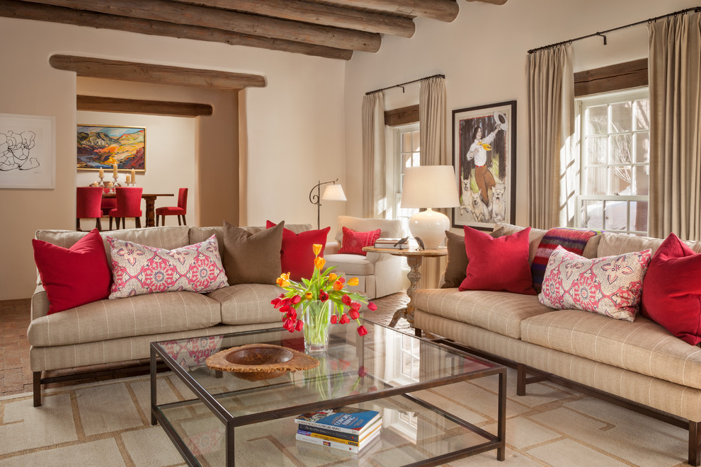 Repräsentatives, Fernseherloses, Offenes Mediterranes Wohnzimmer mit beiger Wandfarbe, dunklem Holzboden, Kamin und Kaminumrandung aus Stein in Albuquerque