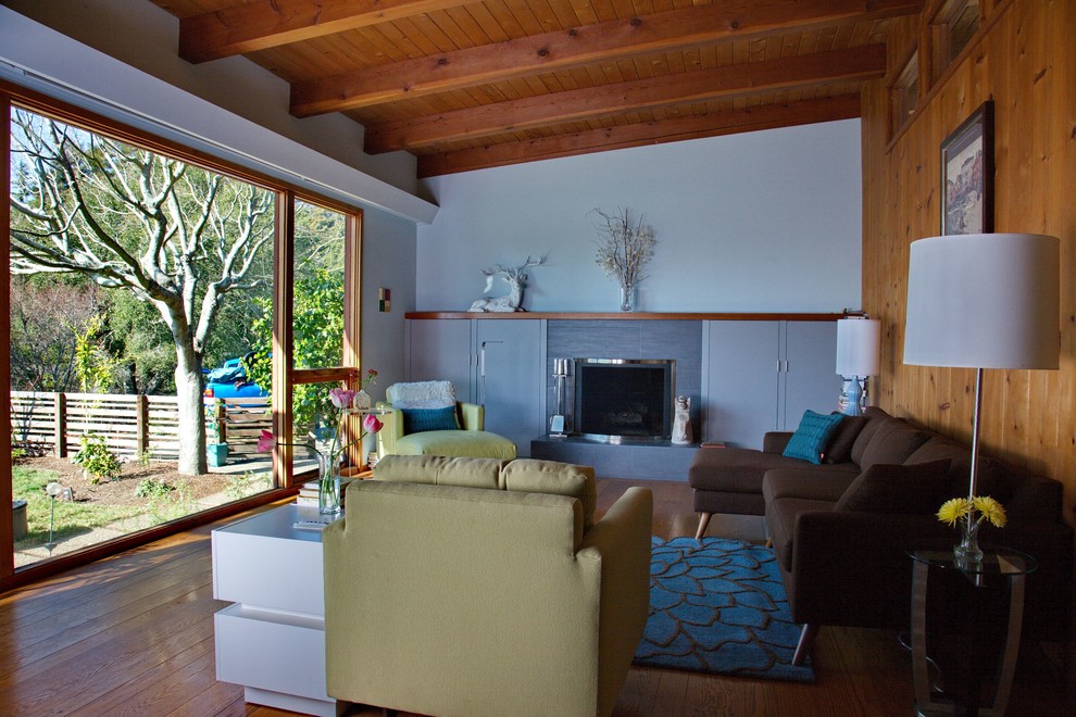 Mittelgroßes, Fernseherloses, Offenes Retro Wohnzimmer mit grauer Wandfarbe, braunem Holzboden, Kamin und braunem Boden in San Francisco