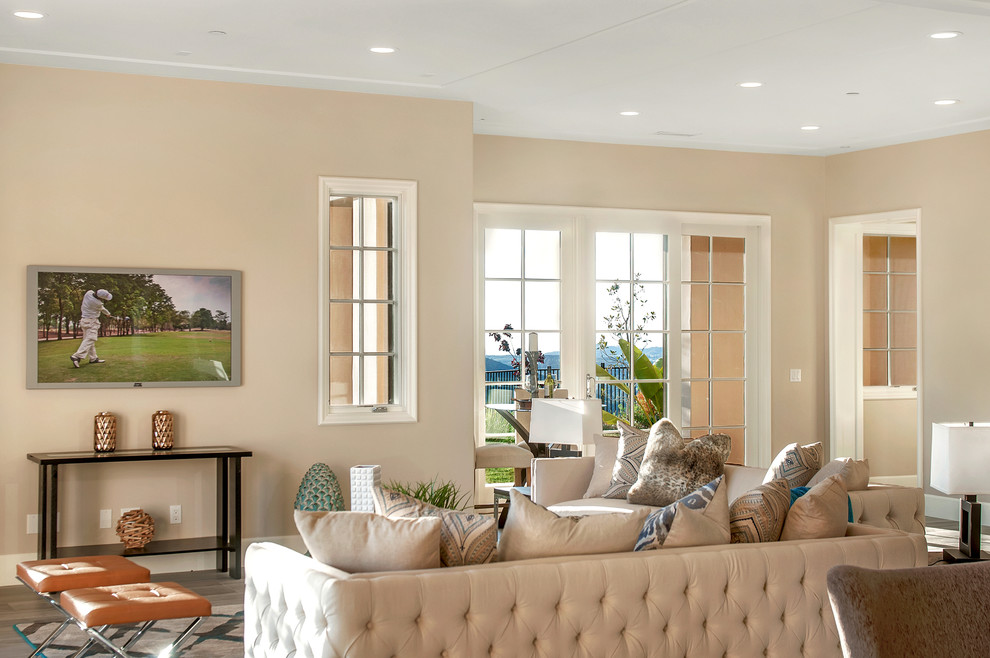 Ispirazione per un grande soggiorno tradizionale aperto con pareti beige, pavimento in legno massello medio e TV a parete