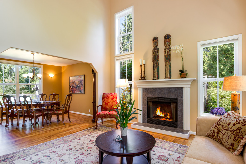 Photo of a large traditional open plan living room in Seattle with beige walls, medium hardwood flooring, a standard fireplace and a stone fireplace surround.