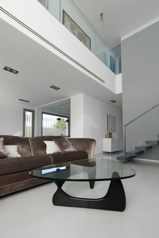 Imagen de salón para visitas abierto contemporáneo con paredes blancas, suelo de cemento, chimenea lineal, marco de chimenea de metal y televisor independiente