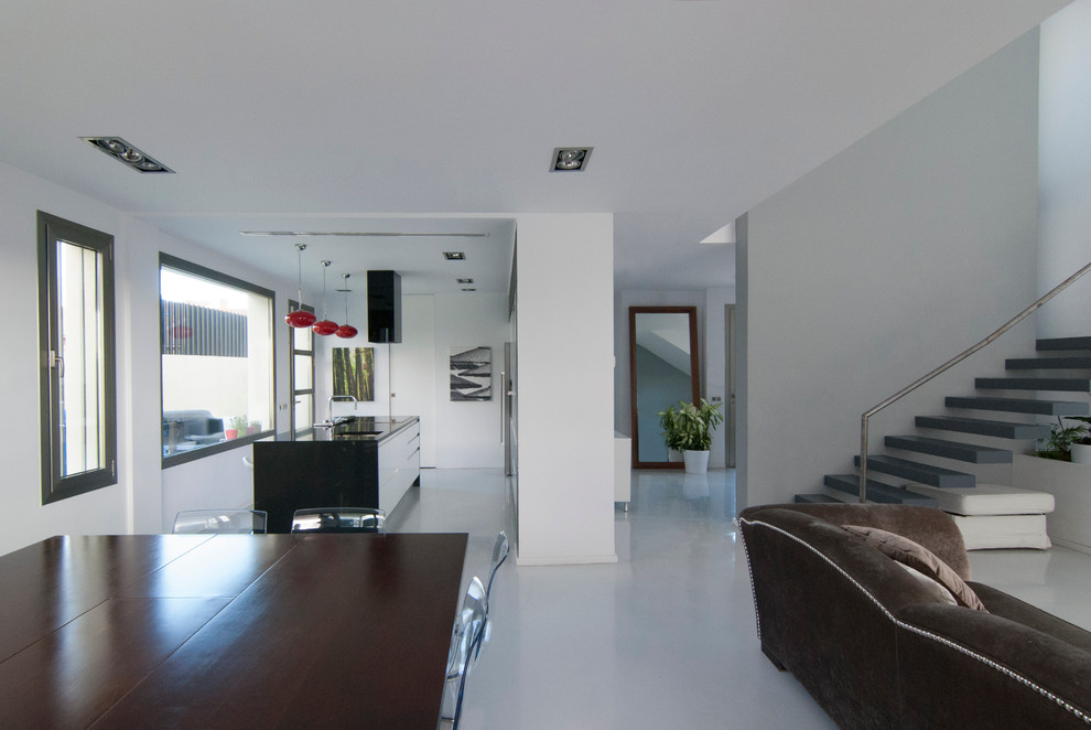Стильный дизайн: парадная, открытая гостиная комната в современном стиле с белыми стенами, бетонным полом, горизонтальным камином, фасадом камина из металла и отдельно стоящим телевизором - последний тренд