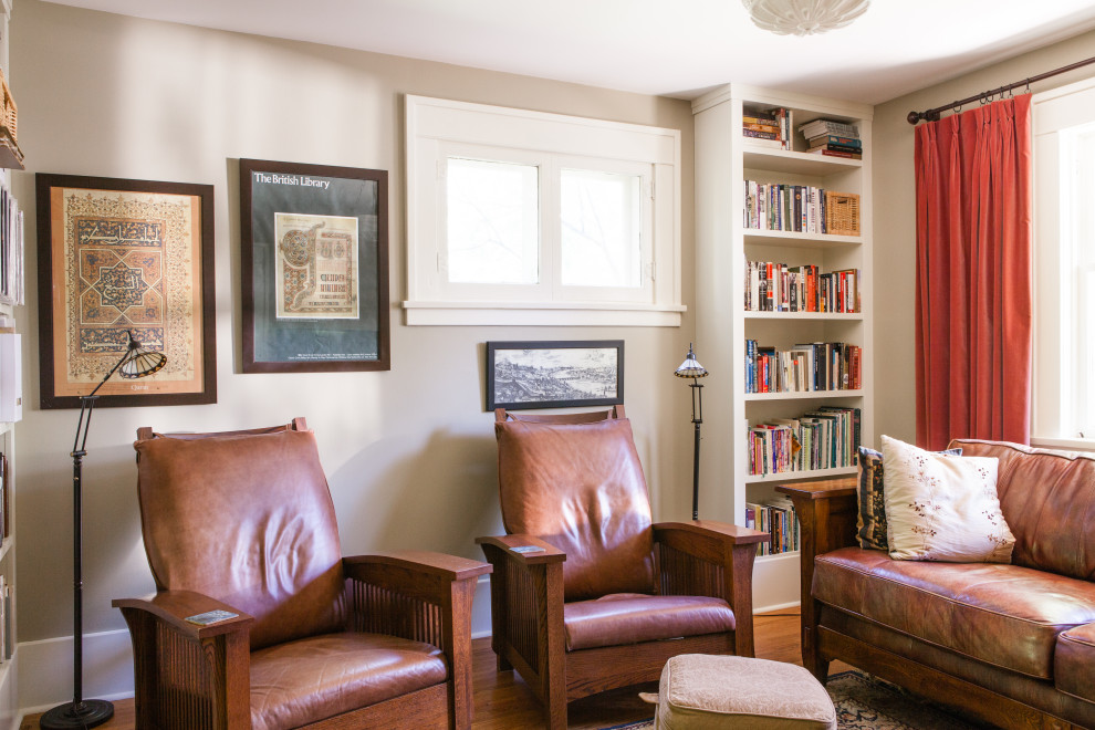 Foto di un soggiorno stile americano di medie dimensioni e chiuso con libreria, pareti verdi, pavimento in legno massello medio e pavimento marrone
