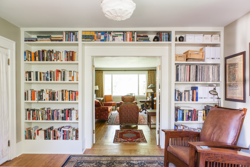 Foto de biblioteca en casa cerrada de estilo americano de tamaño medio con paredes verdes, suelo de madera en tonos medios y suelo marrón