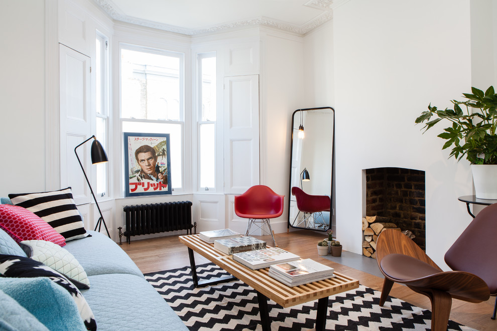 Inspiration for a classic enclosed living room in London with white walls and light hardwood flooring.