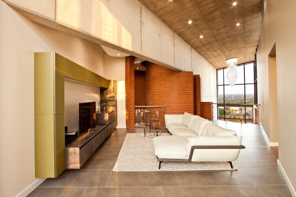 Ispirazione per un soggiorno industriale stile loft con pareti beige, nessun camino, parete attrezzata e pavimento grigio