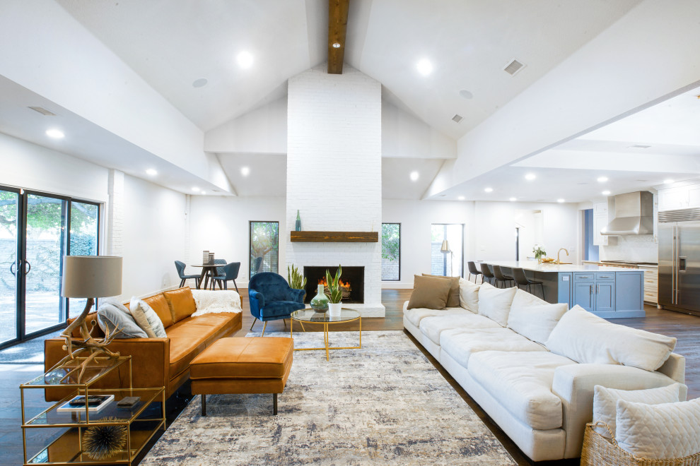 Large mid-century modern open concept dark wood floor, brown floor, vaulted ceiling and brick wall living room photo in Dallas with a bar, white walls, a standard fireplace, a brick fireplace and a media wall