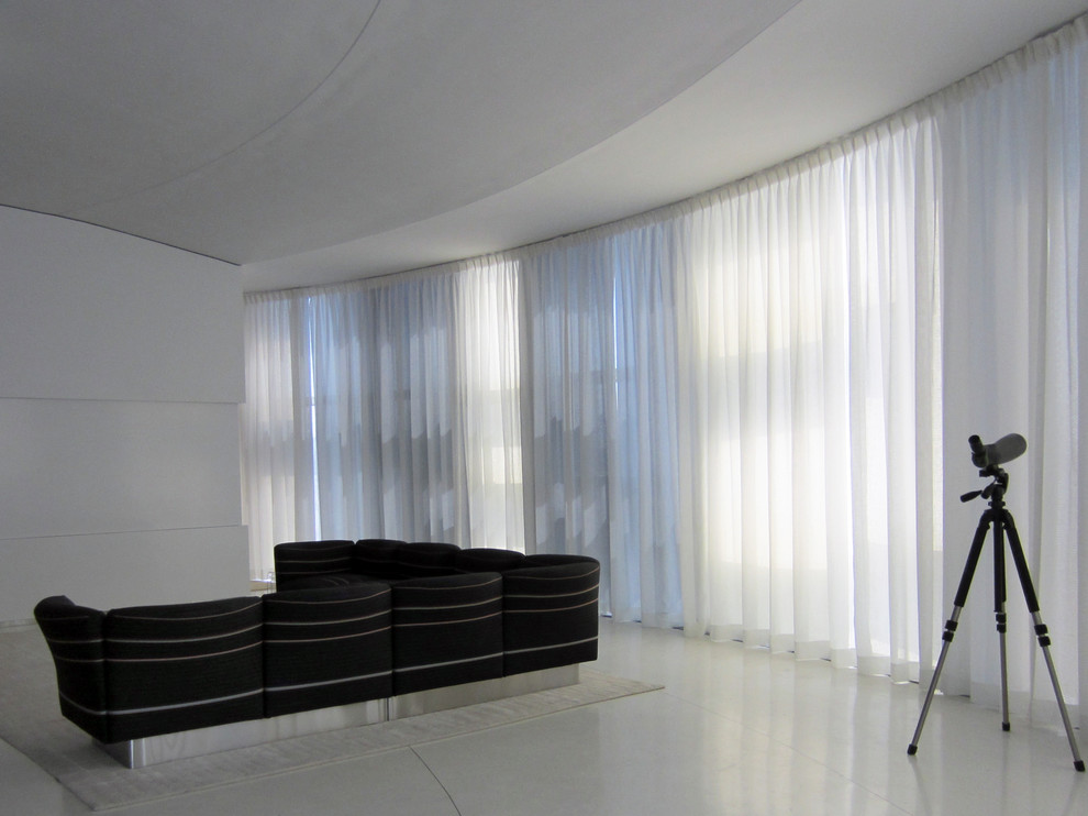 Cette photo montre un grand salon moderne ouvert avec un mur blanc et un téléviseur dissimulé.