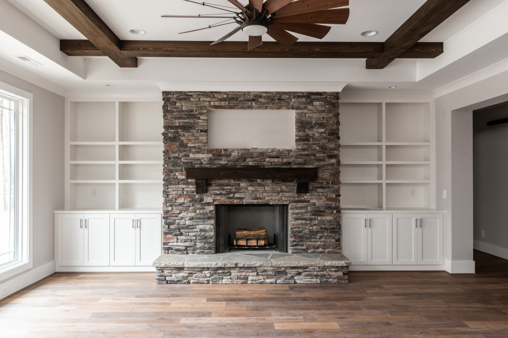 Inspiration for a craftsman open concept medium tone wood floor, exposed beam and shiplap wall living room remodel in Charlotte with beige walls, a wood stove and a stacked stone fireplace