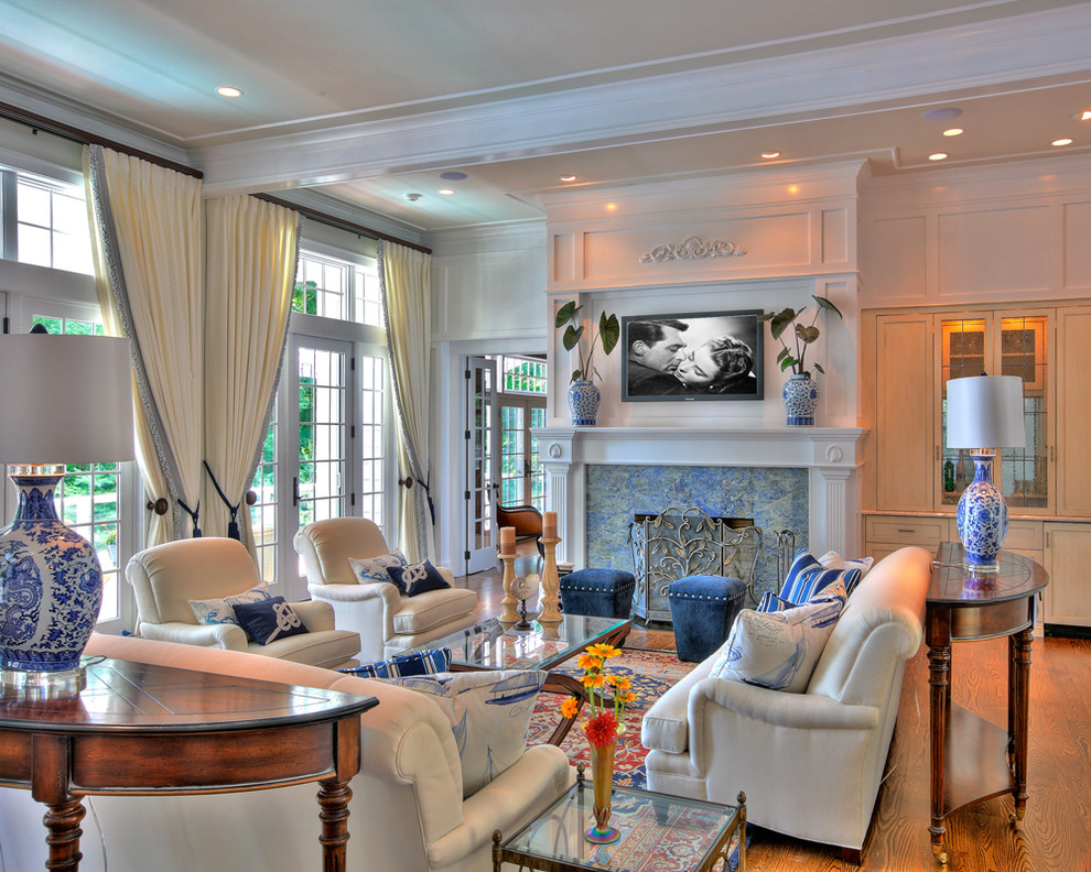 Mid-sized elegant enclosed and formal medium tone wood floor living room photo in New York with a standard fireplace, a stone fireplace, a wall-mounted tv and white walls
