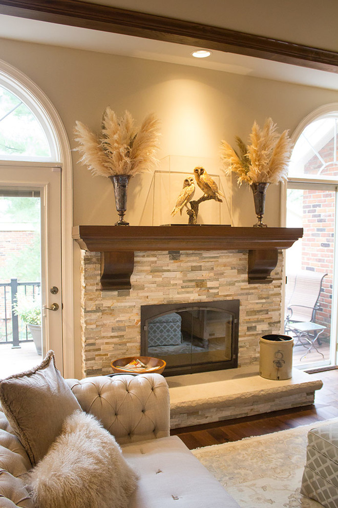 セントルイスにある広いトランジショナルスタイルのおしゃれなリビング (ベージュの壁、無垢フローリング、標準型暖炉、石材の暖炉まわり、茶色い床) の写真