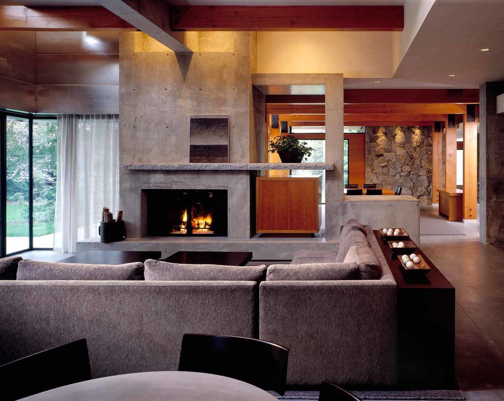 Идея дизайна: большая парадная, открытая гостиная комната в стиле модернизм с серыми стенами, бетонным полом, стандартным камином и фасадом камина из бетона