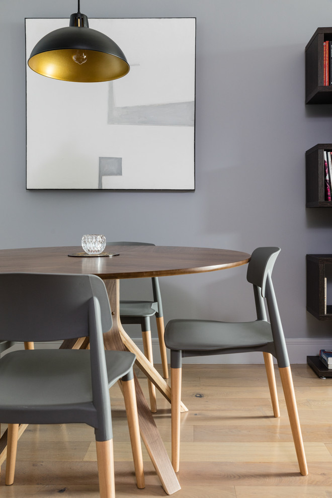 Immagine di una piccola sala da pranzo minimalista con pareti grigie, parquet chiaro e pavimento beige
