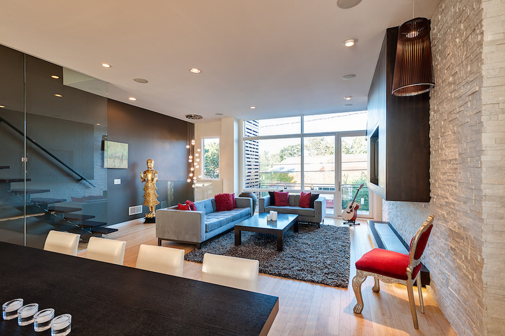 Offenes Modernes Wohnzimmer mit hellem Holzboden und Steinwänden in Cleveland