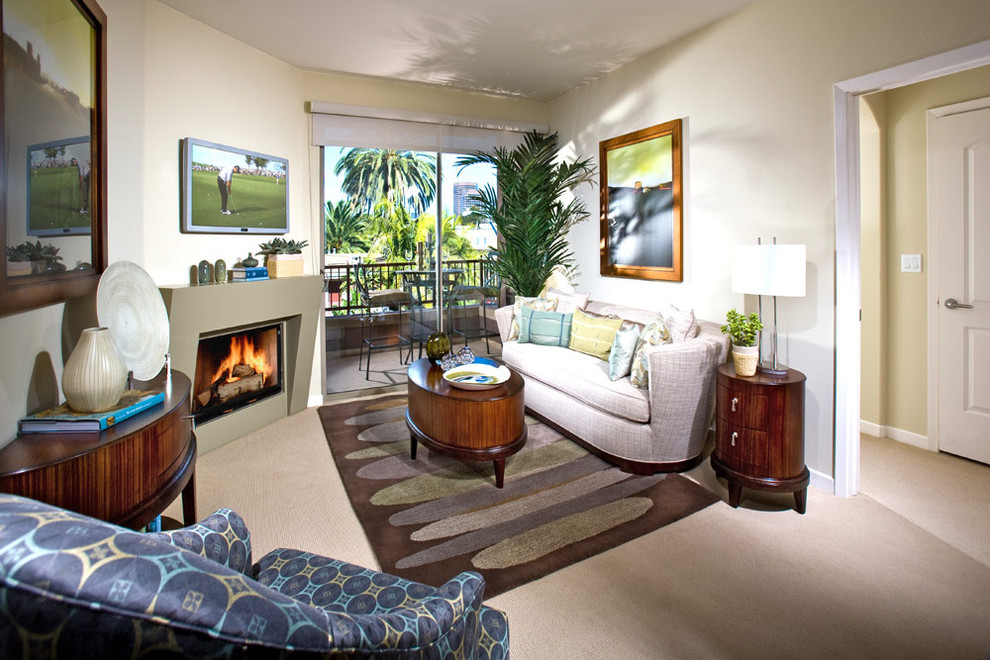 Immagine di un soggiorno design con pareti beige e camino classico