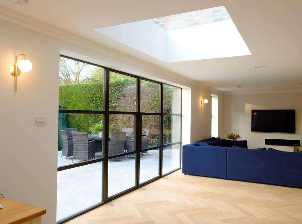 Offenes Modernes Wohnzimmer mit weißer Wandfarbe, hellem Holzboden und braunem Boden in Buckinghamshire