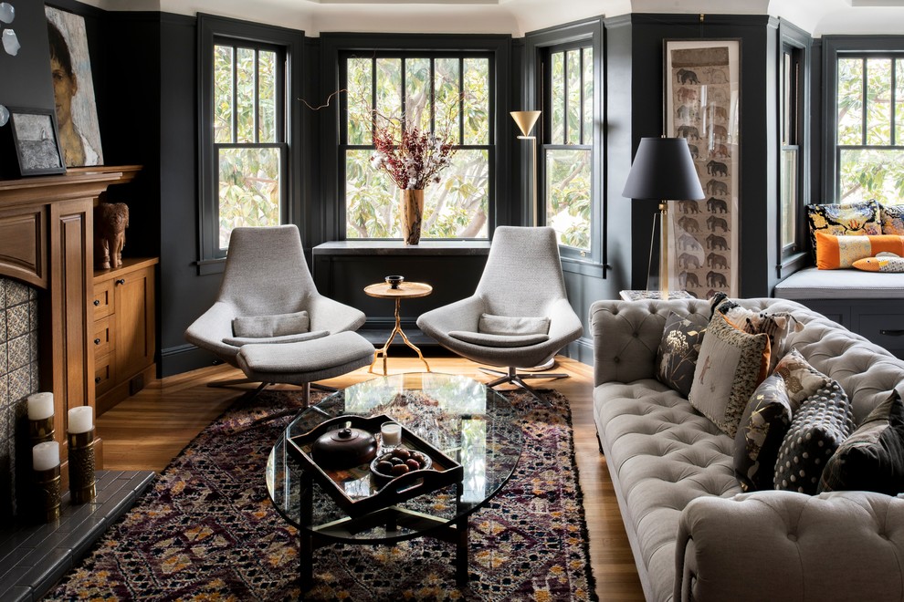 Klassisches Wohnzimmer mit schwarzer Wandfarbe, braunem Holzboden, Kamin, gefliester Kaminumrandung und braunem Boden in San Francisco