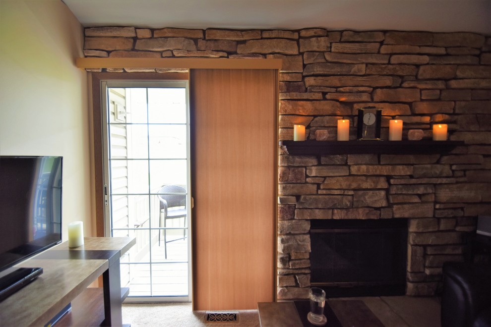 Diseño de salón cerrado rústico pequeño con paredes beige, moqueta, todas las chimeneas, marco de chimenea de piedra y televisor independiente
