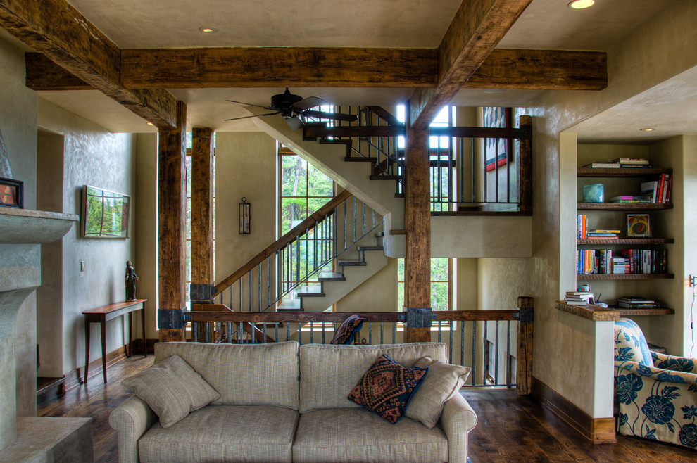 Example of a large mountain style enclosed medium tone wood floor living room design in Other with a standard fireplace and no tv